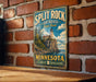 A vintage-style metal sign for Split Rock Lighthouse State Park in Minnesota, featuring a lighthouse on a cliff overlooking a lake.