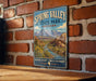 A vintage-style sign for Spring Valley State Park, Nevada, featuring a scenic mountain landscape with a river and lush vegetation.