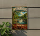 A vintage-style sign for Springbrook State Park in Iowa, featuring a scenic image of a waterfall surrounded by lush greenery.