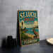 A vintage-style metal sign for St. Lucie Inlet Preserve, Florida, featuring a lighthouse and a pelican, is displayed on a gray countertop.