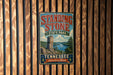 A vintage metal sign for Standing Stone State Park in Tennessee, featuring a scenic landscape with a lake and mountains.