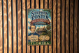 A vintage-style metal sign for Stephen Foster's Folk Culture Center in Florida, featuring a man holding a book titled "The Swan American Song" and a clock.