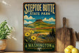 A vintage-style sign for Steptoe Butte State Park in Washington, featuring a mountain landscape with sunflowers and a wooden cutting board in the foreground.