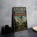A vintage-style metal plaque with the text "Steuben Memorial State Historic Site" and an illustration of a historic building, placed on a gray countertop next to a stack of black camera lenses.
