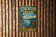 A vintage metal sign for Stockton State Park, Missouri, featuring a scenic lake and mountains in the background.