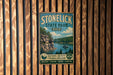 A vintage-style sign for Stonelick State Park, Ohio, featuring a scenic image of a lake surrounded by mountains and forests.