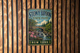 A vintage metal sign for Stony Brook State Park in New York, featuring a scenic illustration of a bridge, waterfall, and forest.