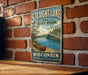 A vintage-style sign for Straight Lake State Park in Wisconsin, featuring a scenic image of a lake with a canoe and surrounded by pine trees.