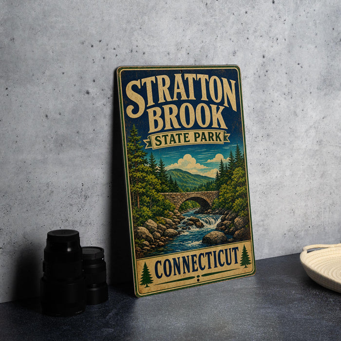 A vintage-style metal sign for Stratton Brook State Park in Connecticut, featuring a scenic landscape with a bridge and waterfall.