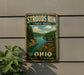 A vintage-style metal sign for Strouds Run State Park in Ohio, featuring a scenic landscape with a lake and mountains.