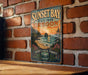 A vintage-style metal sign for Sunset Bay State Park in Oregon, featuring a scenic coastal landscape with a sunset over the ocean.