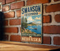 A vintage metal sign for the Swanson Reservoir in Nebraska, featuring a scenic image of a lake and mountains.