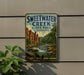 A vintage-style sign for Sweetwater Creek State Park in Georgia, featuring a scenic illustration of a waterfall and lush greenery.