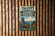 A vintage metal sign for Talcott Mountain State Park in Connecticut, featuring a scenic mountain landscape with a lookout tower.