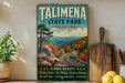 A vintage-style sign for Talimena State Park in Oklahoma, featuring a scenic mountain landscape with winding roads and autumn foliage.