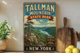 A vintage-style sign for Tallman Mountain State Park in New York, featuring a scenic mountain landscape with a river and pine trees.