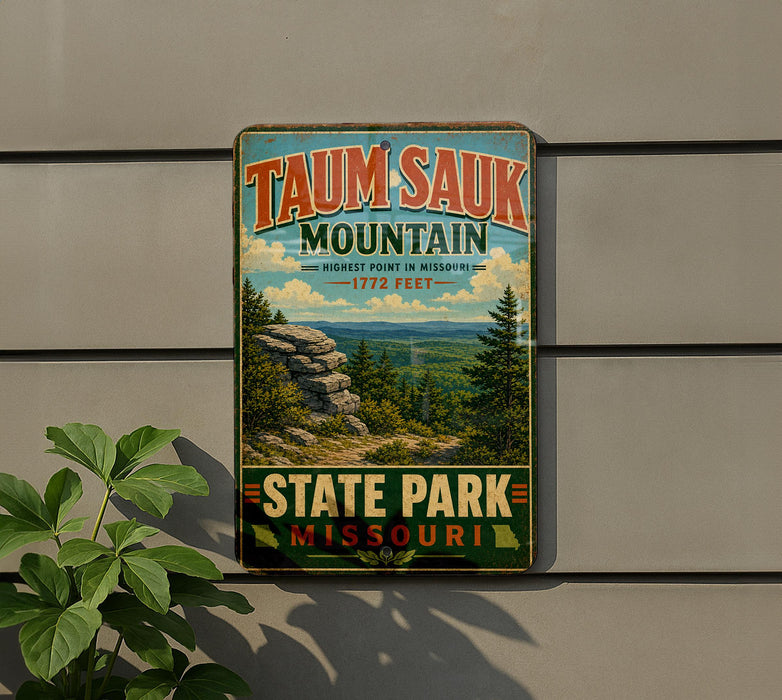 A vintage-style metal sign for Taun sauk Mountain, the highest point in Missouri, with a scenic mountain landscape and pine trees.