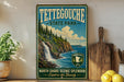 A vintage-style metal sign for Tettegouche State Park, featuring a scenic image of a waterfall and pine trees, is displayed on a shelf next to a wooden cutting board and some lemons.