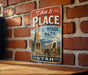 A vintage-style metal sign with the text "This is the PLACE" and "Heritage Park" hangs on a brick wall.