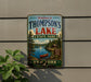 A vintage-style metal sign welcoming visitors to Thompson's Lake State Park in New York.