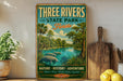 A vintage-style metal sign for "Three Rivers State Park, Florida" featuring a scenic illustration of a river, palm trees, and manatees.