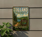A vintage metal sign for Tolland State Forest in Massachusetts, featuring a scenic landscape with pine trees, a lake, and a path leading through the forest.