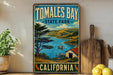 A vintage-style sign for Tomales Bay State Park in California, featuring a scenic landscape with a lake, mountains, and a small boat.