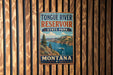 A vintage metal sign for Tongue River Reservoir State Park in Montana, featuring a scenic landscape with a river, mountains, and a boat.