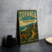 A vintage-style metal sign for Topanga State Park in California, featuring a scenic landscape with mountains, a beach, and flowers.