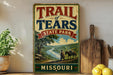 A vintage-style sign for Trail of Tears State Park in Missouri, featuring a scenic illustration of a river and mountains.