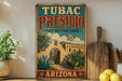 A vintage-style sign for Tubac Presidio State Historic Park in Arizona, featuring an illustration of a historic building surrounded by desert vegetation.