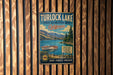 A vintage metal sign for Turlock Lake, California, featuring a scenic image of a lake surrounded by mountains and a boat.