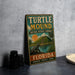 A vintage-style metal sign for Turtle Mound National Historic Landmark in Florida, featuring an illustration of a turtle and a sunset landscape.