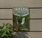 A vintage-style sign for Twin Falls Resort State Park in West Virginia, featuring a waterfall and lush greenery.