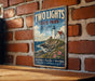 A vintage-style metal sign for "Two Lights State Park" in Maine, featuring a lighthouse and a coastal landscape.
