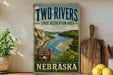 a vintage-style sign for the Two Rivers State Recreation Area in Nebraska, with a scenic illustration of a river and mountains.