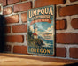 A vintage-style metal sign for Umpqua Lighthouse State Park, featuring a lighthouse and a scenic coastal landscape.