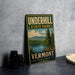 A vintage metal sign for Underhill State Park in Vermont, featuring a scenic landscape with a lake and mountains.