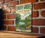 A vintage-style metal sign for Union Grove State Park in Iowa, featuring a scenic illustration of a lake surrounded by trees and a path.