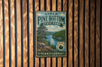 A vintage-style metal sign for Upper Pine Bottom State Park in Pennsylvania, featuring a scenic landscape with pine trees, a river, and mountains.