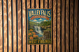 A vintage metal sign for Valley Falls State Park in West Virginia, featuring a waterfall and surrounding landscape.