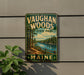 A vintage metal sign for Vaughan Woods State Park in Maine, featuring a scenic landscape with a river, trees, and a wooden fence.