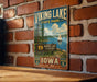 A vintage-style metal sign for Viking Lake State Park in Iowa, featuring a scenic illustration of a lake with a sailboat and surrounded by trees.