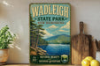A vintage-style poster of Wadelligh State Park in New Hampshire, featuring a scenic landscape with a lake, mountains, and pine trees.