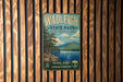 A vintage metal sign for Wadleigh State Park in New Hampshire, featuring a scenic landscape with pine trees, a lake, and mountains.