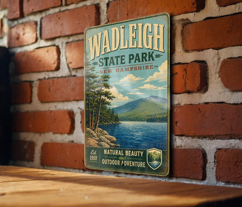 A vintage-style metal sign for Wadleigh State Park in New Hampshire, featuring a scenic landscape with a lake, mountains, and pine trees.