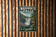 A vintage metal sign for Wadsworth Falls State Park in Connecticut, featuring a scenic waterfall surrounded by lush greenery.