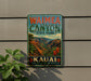 A vintage-style metal sign for Waimea Canyon State Park in Kauai, Hawaii, featuring a scenic landscape with mountains, palm trees, and colorful flowers.