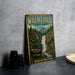 A vintage-style metal sign for Wallace Falls State Park in Washington, featuring a scenic illustration of the waterfall surrounded by pine trees and mountains.