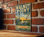 A vintage-style metal sign for Walnut Point State Fish & Wildlife Area in Illinois, featuring illustrations of birds and a sunset over a lake.